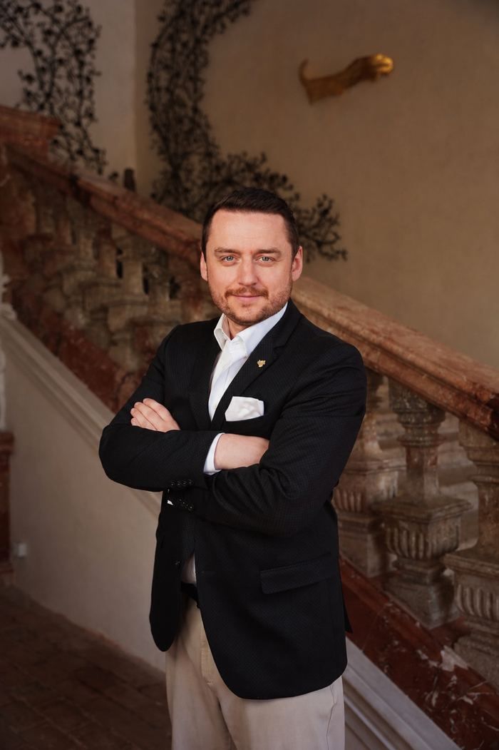 Bernhard Kick im dunklen Sakko vor einer Treppe